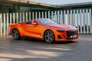 Bentley Batur front view featuring diamond patterned gloss black grille with orange accents and sharp eagle eye shaped headlights with flying wings bentley badge on leading end.